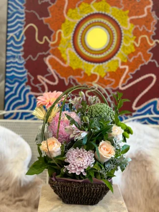 Mother's Day Floral Basket: A captivating arrangement celebrating Mom, adorned with an exquisite blend of roses, gerberas, and chrysanthemums, accented with lush greenery and elegantly wrapped with spear grass overhead. A delightful expression of love and gratitude.